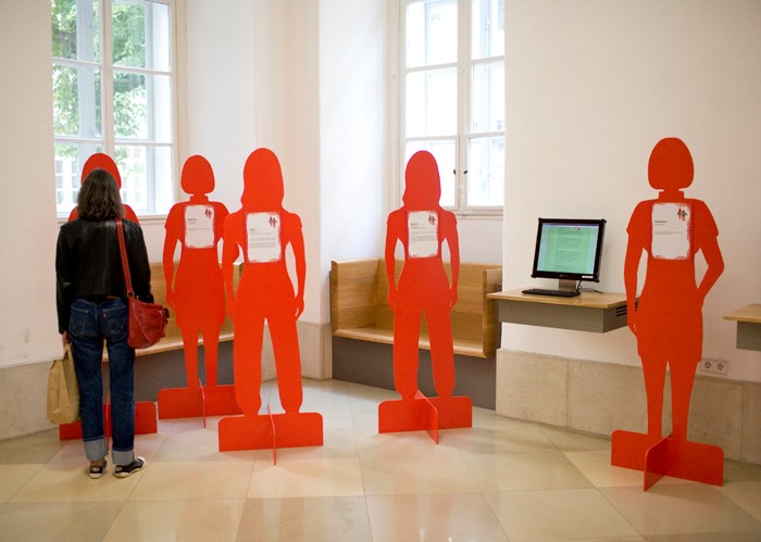 Besucherin betrachtet Figuren